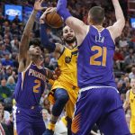 Utah Jazz guard Ricky Rubio, center, drives to the basket as Phoenix Suns' Elfrid Payton (2) and Alex Len (21) defend during the first half of an NBA basketball game Thursday, March 15, 2018, in Salt Lake City. (AP Photo/Rick Bowmer)