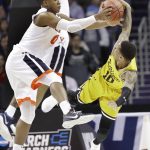 Virginia's Devon Hall (0) ties up UMBC's Jairus Lyles (10) during the first half of a first-round game in the NCAA men's college basketball tournament in Charlotte, N.C., Friday, March 16, 2018. (AP Photo/Gerry Broome)