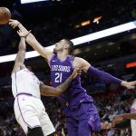 Phoenix Suns' Alex Len (21) gets a rebound over Miami Heat's Rodney McGruder, left, and Dwyane Wade, right, during the first half of an NBA basketball game, Monday, March 5, 2018, in Miami. (AP Photo/Lynne Sladky)