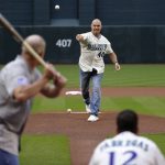 Former Arizona Diamondbacks pitcher Andy Benes (40) throws the ceremonial first pitch to former Colorado Rockies' Mike Lansing as former Diamondbacks catcher Jorge Fabregas (12) catches prior to a baseball game Saturday, March 31, 2018, in Phoenix. The pitch re-created the first pitch delivered to the first batter in the first-ever Diamondbacks game on March 31, 1998. (AP Photo/Matt York)