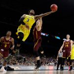 Michigan guard Zavier Simpson (3) drives to the basket between Loyola-Chicago's Donte Ingram, left, and Clayton Custer during the second half in the semifinals of the Final Four NCAA college basketball tournament, Saturday, March 31, 2018, in San Antonio. (AP Photo/David J. Phillip)