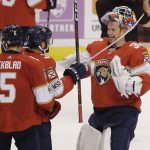 Florida Panthers goaltender James Reimer (34) celebrates with teammates Aaron Ekblad (5) and Keith Yandle (3) after they won an NHL hockey game against the Arizona Coyotes in Sunrise, Fla. on Saturday, March 24, 2018. (AP Photo/Terry Renna)