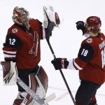 Arizona Coyotes goaltender Antti Raanta (32) celebrates a win against the Calgary Flames with center Christian Dvorak (18) as time expires in the third period of an NHL hockey game, Monday, March 19, 2018, in Glendale, Ariz. The Coyotes defeated the Flames 5-2. (AP Photo/Ross D. Franklin)