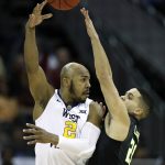 West Virginia's Jevon Carter (2) passes over Baylor's Manu Lecomte during the first half of an NCAA college basketball game in the Big 12 men's tournament Thursday, March 8, 2018, in Kansas City, Mo. (AP Photo/Charlie Riedel)