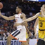 Virginia's Isaiah Wilkins (21) grab a rebound against UMBC's Joe Sherburne (13) during the first half of a first-round game in the NCAA men's college basketball tournament in Charlotte, N.C., Friday, March 16, 2018. (AP Photo/Gerry Broome)