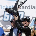 Kevin Harvick holds up the trophy after winning a NASCAR Cup Series auto race on Sunday, March 11, 2018, in Avondale, Ariz. (AP Photo/Rick Scuteri)