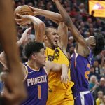 Phoenix Suns' Josh Jackson, right, and Devin Booker (1) defend against Utah Jazz center Rudy Gobert, center, during the first half of an NBA basketball game Thursday, March 15, 2018, in Salt Lake City. (AP Photo/Rick Bowmer)