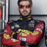 Martin Truex Jr. (78) sits in the shade before a NASCAR Cup Series auto race on Sunday, March 11, 2018, in Avondale, Ariz. (AP Photo/Rick Scuteri)