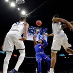 Kansas guard Devonte' Graham (4) shoots between Villanova defenders during the first half in the semifinals of the Final Four NCAA college basketball tournament, Saturday, March 31, 2018, in San Antonio. (AP Photo/David J. Phillip)