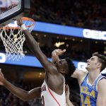 UCLA's Gyorgy Goloman, right, fouls Arizona's Deandre Ayton during the second half of an NCAA college basketball game in the semifinals of the Pac-12 men's tournament Friday, March 9, 2018, in Las Vegas. Arizona won 78-67 in overtime. (AP Photo/Isaac Brekken)