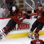 Arizona Coyotes defenseman Oliver Ekman-Larsson, left, celebrates his goal against the Calgary Flames with center Christian Dvorak (18), as left wing Max Domi, front right, looks on during the third period of an NHL hockey game, Monday, March 19, 2018, in Glendale, Ariz. The Coyotes defeated the Flames 5-2. (AP Photo/Ross D. Franklin)