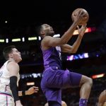 Phoenix Suns' TJ Warren, center, drives past Miami Heat's Luke Babbitt, left, and Hassan Whiteside, right, during the first half of an NBA basketball game, Monday, March 5, 2018, in Miami. (AP Photo/Lynne Sladky)