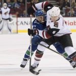 Vancouver Canucks right wing Nikolay Goldobin (77) vies for control of the puck with Arizona Coyotes defenseman Jakob Chychrun (6) during the first period of an NHL hockey game Wednesday, March 7, 2018, in Vancouver, British Columbia. (Jonathan Hayward/The Canadian Press via AP)