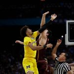 Michigan's Isaiah Livers (4) and Loyola-Chicago's Cameron Krutwig (25) battle for the ball at the tip off during the first half in the semifinals of the Final Four NCAA college basketball tournament, Saturday, March 31, 2018, in San Antonio. (AP Photo/David J. Phillip)