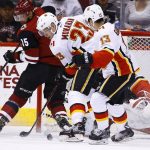 Calgary Flames center Sean Monahan (23) kicks the puck out to left wing Johnny Gaudreau (13) after a shot by Arizona Coyotes center Brad Richardson (15) during the first period of an NHL hockey game Monday, March 19, 2018, in Glendale, Ariz. (AP Photo/Ross D. Franklin)