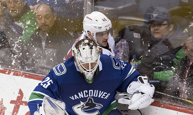 Arizona Coyotes right wing Josh Archibald (45) tries to squeeze behind Vancouver Canucks goaltender...