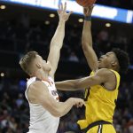 UMBC's Daniel Akin, right, shoots over Virginia's Jack Salt during the first half of a first-round game in the NCAA men's college basketball tournament in Charlotte, N.C., Friday, March 16, 2018. (AP Photo/Bob Leverone)