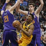 Utah Jazz guard Donovan Mitchell, center, drives to the basket as Phoenix Suns center Alex Len (21) and forward Dragan Bender, right, defend during the first half during an NBA basketball game Thursday, March 15, 2018, in Salt Lake City. (AP Photo/Rick Bowmer)