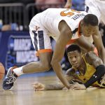 UMBC's Jairus Lyles (10) passes the ball as Virginia's Mamadi Diakite (25) defends during the first half of a first-round game in the NCAA men's college basketball tournament in Charlotte, N.C., Friday, March 16, 2018. (AP Photo/Gerry Broome)