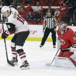 Arizona Coyotes' Christian Dvorak (18) takes a pass in front of Carolina Hurricanes goalie Cam Ward (30) during the first period of an NHL hockey game in Raleigh, N.C., Thursday, March 22, 2018. (AP Photo/Gerry Broome)