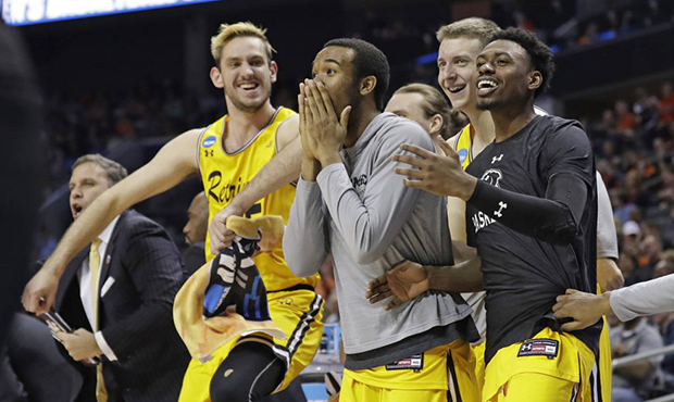 UMBC players celebrate a teammate's basket against Virginia during the second half of a first-round...