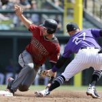 Arizona Diamondbacks' A.J. Pollock, left, is tagged out stealing by Colorado Rockies shortstop Trevor Story during the second inning of a spring baseball game in Scottsdale, Ariz., Sunday, March 25, 2018. (AP Photo/Chris Carlson)