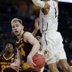 Arizona State's Kodi Justice passes under Colorado's Tyler Bey during the first half of an NCAA college basketball game in the first round of the Pac-12 men's tournament Wednesday, March 7, 2018, in Las Vegas. (AP Photo/Isaac Brekken)