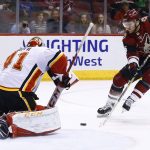 Arizona Coyotes right wing Christian Fischer (36) tries to get off a shot on Calgary Flames goaltender Mike Smith (41) during the second period of an NHL hockey game Monday, March 19, 2018, in Glendale, Ariz. (AP Photo/Ross D. Franklin)