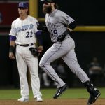 Colorado Rockies' Charlie Blackmon (19) rounds the bases after hitting a solo home run as Arizona Diamondbacks' Jake Lamb (22) looks on during the eighth inning of a baseball game Saturday, March 31, 2018, in Phoenix. (AP Photo/Matt York)