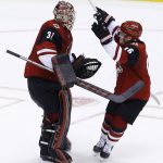 Arizona Coyotes goaltender Adin Hill (31) celebrates his first NHL win with left wing Max Domi (16) after a shootout of an NHL hockey game against the Los Angeles Kings Tuesday, March 13, 2018, in Glendale, Ariz. The Coyotes defeated the Kings 4-3. (AP Photo/Ross D. Franklin)