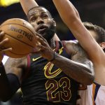 Cleveland Cavaliers forward LeBron James (23) gets fouled by Phoenix Suns forward Dragan Bender in the first half of an NBA basketball game, Tuesday, March 13, 2018, in Phoenix. (AP Photo/Rick Scuteri)