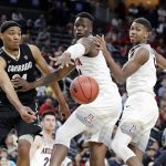 Colorado's George King, left, passes behind Arizona's Emmanuel Akot, center, and Brandon Randolph during the second half of an NCAA college basketball game in the quarterfinals of the Pac-12 men's tournament Thursday, March 8, 2018, in Las Vegas. Arizona won 83-67. (AP Photo/Isaac Brekken)