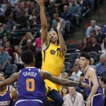 Utah Jazz guard Dante Exum (11) lays the ball up as Phoenix Suns' Marquese Chriss (0) and Devin Booker, right, watch during the first half of an NBA basketball game Thursday, March 15, 2018, in Salt Lake City. (AP Photo/Rick Bowmer)