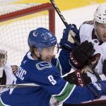 Arizona Coyotes defenseman Jason Demers (55) tries to clear Vancouver Canucks left wing Brendan Leipsic (9) from in front of Coyotes goaltender Darcy Kuemper during the third period of an NHL hockey game Wednesday, March 7, 2018, in Vancouver, British Columbia. (Jonathan Hayward/The Canadian Press via AP)