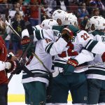 Minnesota Wild right wing Nino Niederreiter (22) celebrates his goal against the Arizona Coyotes with defenseman Matt Dumba (24), left wing Jason Zucker (16), and others as Coyotes center Brad Richardson (15) skates past during the first period of an NHL hockey game Saturday, March 17, 2018, in Glendale, Ariz. (AP Photo/Ross D. Franklin)