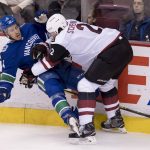Arizona Coyotes defenseman Luke Schenn (2) puts Vancouver Canucks defenseman Michael Del Zotto (4) to the ice during the second period of an NHL hockey game Wednesday, March 7, 2018, in Vancouver, British Columbia. (Jonathan Hayward/The Canadian Press via AP)