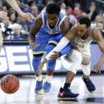 UCLA's Aaron Holiday, left, and Arizona's Parker Jackson-Cartwright reach for a loose ball during the first half of an NCAA college basketball game in the semifinals of the Pac-12 men's tournament Friday, March 9, 2018, in Las Vegas. (AP Photo/Isaac Brekken)