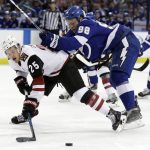 Tampa Bay Lightning defenseman Mikhail Sergachev (98) takes down Arizona Coyotes center Nick Cousins (25) during the first period of an NHL hockey game Monday, March 26, 2018, in Tampa, Fla. (AP Photo/Chris O'Meara)