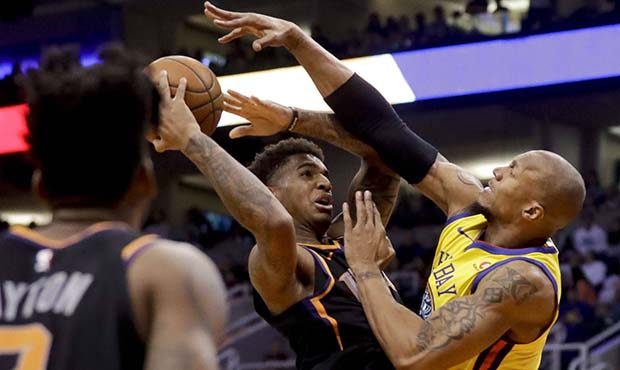 Phoenix Suns forward Marquese Chriss tries to shoot over Golden State Warriors forward David West d...