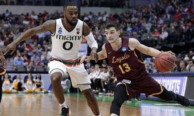 Miami guard Ja'Quan Newton (0) defends against a drive to the basket by Loyola-Chicago guard Clayto...
