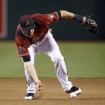 Arizona Diamondbacks shortstop Nick Ahmed reaches down to barehand a ground ball hit by San Diego Padres' Matt Szczur before throwing to first base for the out during the seventh inning of a baseball game Sunday, April 22, 2018, in Phoenix. The Diamondbacks defeated the Padres 4-2. (AP Photo/Ross D. Franklin)