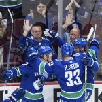 Vancouver Canucks' Daniel Sedin, Henrik Sedin and Alexander Edler, from left, all of Sweden, celebrate Daniel Sedin's goal against the Arizona Coyotes during the second period of an NHL hockey game Thursday, April 5, 2018, in Vancouver, British Columbia. (Darryl Dyck//The Canadian Press via AP)