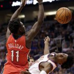 Phoenix Suns forward Marquese Chriss fouls New Orleans Pelicans guard Jrue Holiday (11) during the first half of an NBA basketball game Friday, April 6, 2018, in Phoenix. (AP Photo/Matt York)