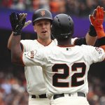 San Francisco Giants' Buster Posey, left, is congratulated by Andrew McCutchen (22) after hitting a two run home run off Arizona Diamondbacks' Robbie Ray in the fifth inning of a baseball game Wednesday, April 11, 2018, in San Francisco. (AP Photo/Ben Margot)