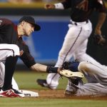 Arizona Diamondbacks shortstop Nick Ahmed, left, tags out San Diego Padres' Franchy Cordero who was trying to steal second base during the sixth inning of a baseball game Saturday, April 21, 2018, in Phoenix. (AP Photo/Ross D. Franklin)