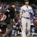Los Angeles Dodgers' Cody Bellinger, right, walks back to the dugout after being called out on strikes by umpire Jerry Layne (24) during the first inning of a baseball game against the Arizona Diamondbacks Monday, April 30, 2018, in Phoenix. (AP Photo/Ross D. Franklin)
