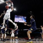 Villanova guard Donte DiVincenzo dunks the ball over Michigan guard Charles Matthews during the first half in the championship game of the Final Four NCAA college basketball tournament, Monday, April 2, 2018, in San Antonio. (AP Photo/Eric Gay)