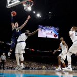 Michigan forward Moritz Wagner (13) drives to the basket over Villanova forward Eric Paschall during the second half in the championship game of the Final Four NCAA college basketball tournament, Monday, April 2, 2018, in San Antonio. (AP Photo/Eric Gay)