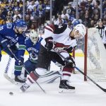 Arizona Coyotes' Richard Panik (14), of Slovakia, looks for the puck after it got caught in his skates in front of Vancouver Canucks goalie Jacob Markstrom (25), of Sweden, as Alexander Edler (23), of Sweden, watches during the first period of an NHL hockey game Thursday, April 5, 2018, in Vancouver, British Columbia. (Darryl Dyck/The Canadian Press via AP)