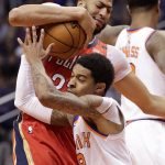 Phoenix Suns guard Tyler Ulis tries to steal the ball from New Orleans Pelicans forward Anthony Davis, top, during the second half of an NBA basketball game Friday, April 6, 2018, in Phoenix. (AP Photo/Matt York)
